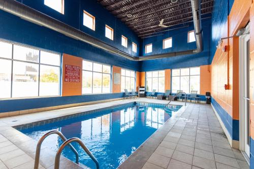 a large swimming pool with blue walls and windows at Kalika Hotel in Niagara Falls