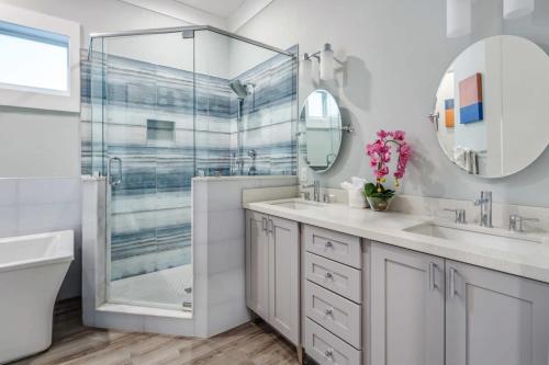 a white bathroom with two sinks and a shower at Modern Keys by Brightwild-Waterfront w Dock in Key West