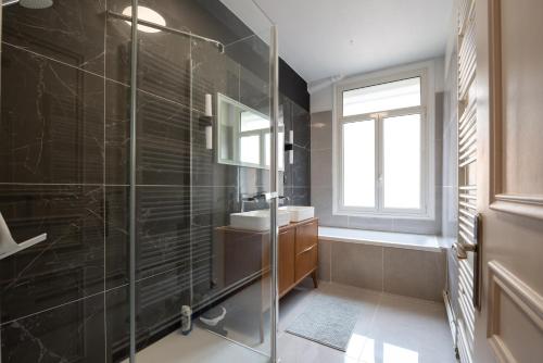 une salle de bain avec une douche en verre et un lavabo dans l'établissement Spacieux 4 chambres - Hyper Centre-ville, à Amiens
