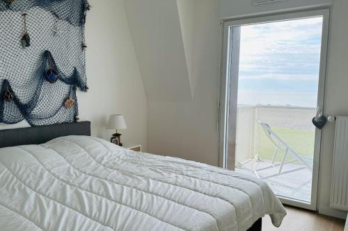 Schlafzimmer mit einem Bett und einem Fenster mit einem Stuhl in der Unterkunft Face à la mer immense in Cayeux-sur-Mer