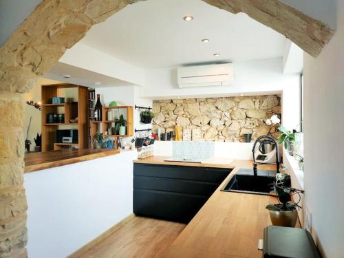een keuken met een stenen muur en een aanrecht bij Mas de la Grande Bastide, piscine, vue panoramique in Tourrettes