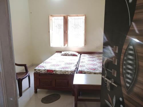 um pequeno quarto com uma cama e uma janela em Budha ashram guest house em Bodh Gaya