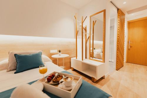 ein Wohnzimmer mit einem Sofa und einem Tisch mit einem Tablett mit Essen in der Unterkunft HOTEL LOTUS in Caldas de Reis