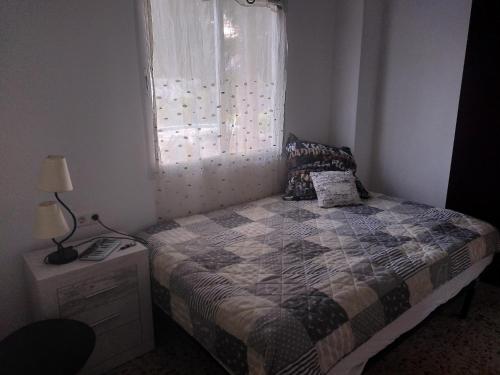 a small bedroom with a bed and a window at Finca Caracol in Bolulla