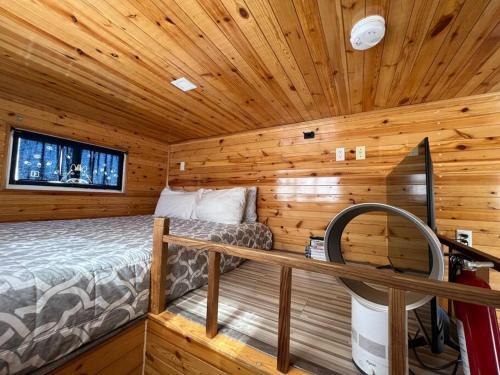 a bedroom in a log cabin with a bed at Tiny House - mountain views close to everything in Valley Center