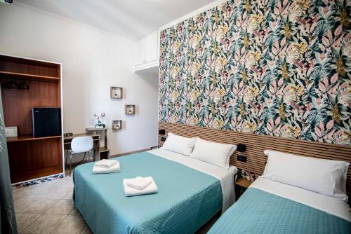 ローマにあるホテル デル ウルべのベッド2台と壁紙が備わるホテルルームです。