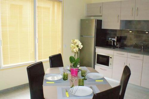 a kitchen with a table with plates and flowers on it at Appartement d'une chambre avec sauna et wifi a La Ferriere aux Etangs in La Ferrière-aux-Étangs