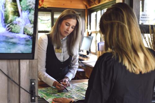 two women standing at a counter looking at a map at Lakeside Hotel Plitvice in Plitvička Jezera