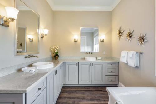 a bathroom with two sinks and a large mirror at Coastal Bliss by Brightwild-Pool, Parking, Dock! in Key West