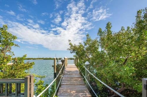 a wooden walkway leading to a dock on a lake at Evershore House -Pool, Parking, Dock! in Key West