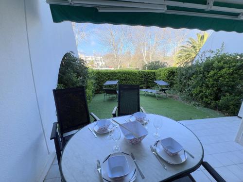 une table blanche avec des verres à vin sur une terrasse dans l'établissement Sol-y-Days Martinic, rez-de-jardin a deux pas des plages, à La Grande Motte
