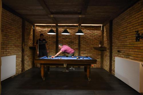 a man is playing pool on a pool table at Lakeside Hotel Plitvice in Plitvička Jezera