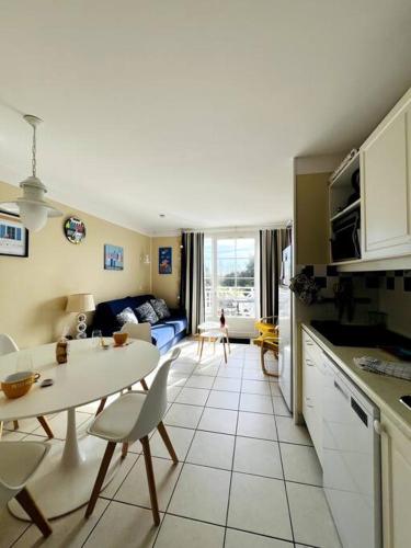 une cuisine et un salon avec une table et un canapé dans l'établissement Embruns - Appartement au calme, à Talmont-Saint-Hilaire