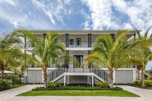 a white building with palm trees in front of it at New The Windrose House - Pool & Pets in Key West