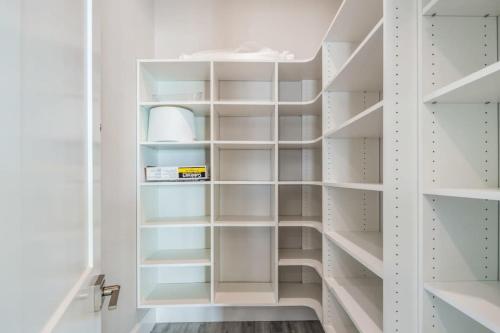 a walk in closet with white shelves at Mastway House -Pool & Dock! in Key West