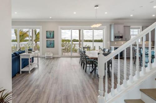 a dining room and living room with a table and a kitchen at Mastway House -Pool & Dock! in Key West