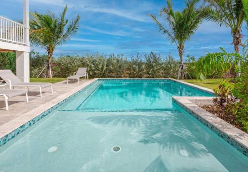a swimming pool with palm trees and a villa at Mastway House -Pool & Dock! in Key West