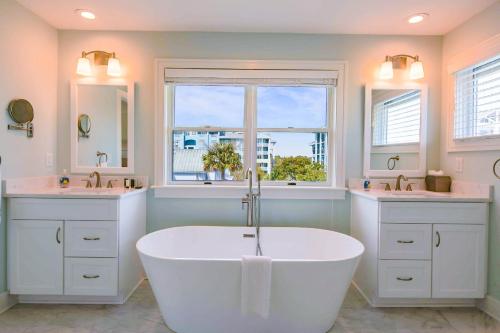 baño con bañera blanca y 2 lavabos en Coastal Chic, en Isle of Palms