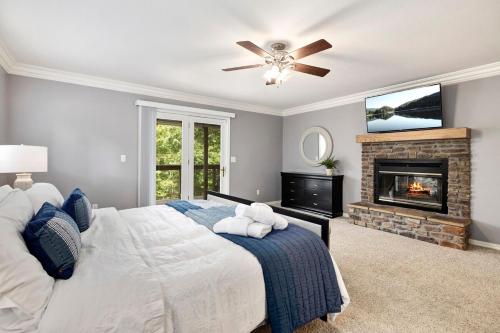 ein Schlafzimmer mit einem großen Bett und einem Kamin in der Unterkunft Lakeside Hideaway - Lake House Cabin with Views in Rogers