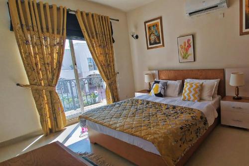 a bedroom with a bed and a large window at Villa 23 in Islamabad