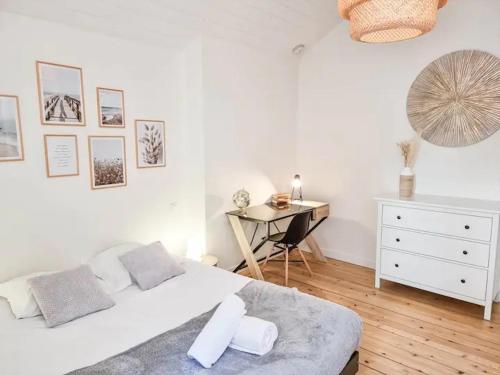 ein weißes Schlafzimmer mit einem Bett und einem Schreibtisch in der Unterkunft Le T3 du Carnot in Annecy