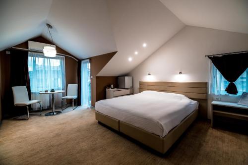 a bedroom with a large bed and a desk and aaptop at Sienna Apartments in Skopje