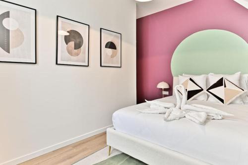 - une chambre avec un lit blanc et un mur rose dans l'établissement Appartement spacieux à 5 minutes de la capitale, à Bagnolet