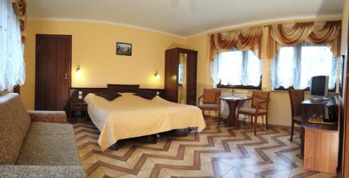 ポラニツァ・ズドルイにあるPokoje Gościnne Akacjaのベッドルーム1室(ベッド1台、テーブル、椅子付)