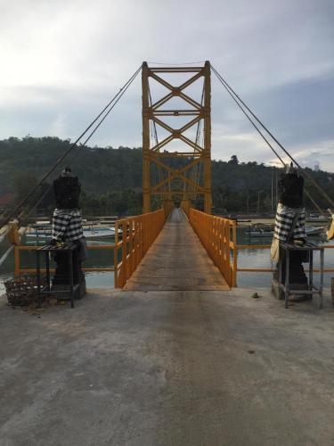 a bridge over a body of water with two people on it at Maha di Nusa Lembongan in Nusa Lembongan
