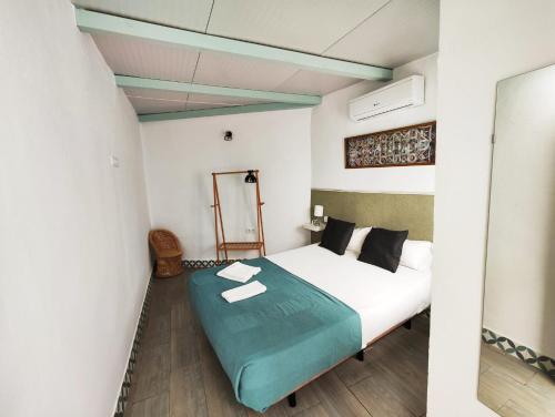 a bedroom with a white bed with a green blanket at Apartamento PUERTA DE CÓRDOBA in Carmona