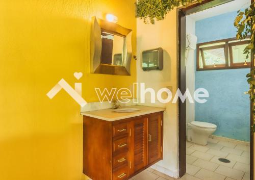 uma casa de banho amarela com um lavatório e um WC em Sítio com piscina e churrasqueira em Indaiatuba em Campinas