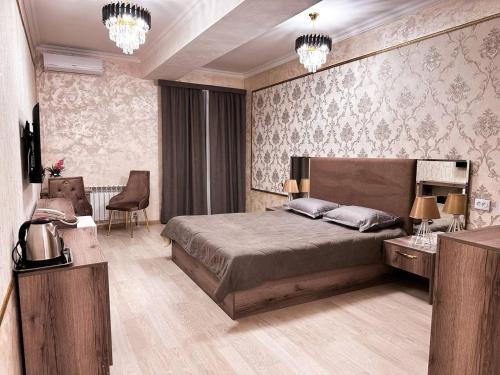 Stela Hotel في شيمكنت: غرفة نوم بسرير وطاولة وكراسي