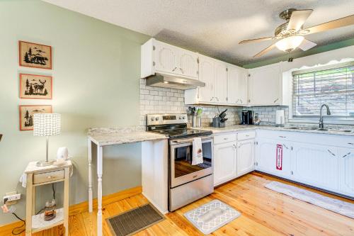 a kitchen with white cabinets and a ceiling fan at Pet-Friendly Hiawassee Cabin with Lake Views and Sauna in Hiawassee