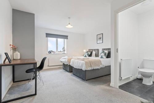 a bedroom with a bed and a desk and a toilet at Anglian Retreat - Close to City Centre - Free Parking, Fast Wifi and Smart TV by Yoko Property in Coventry