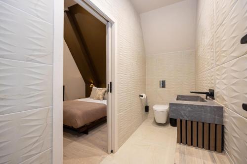 a small bathroom with a sink and a bed at Atisuto Residence by CasaCity in Manchester