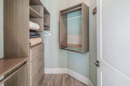 a walk in closet with wooden cabinets and a mirror at Waterlane House -Pool & Boat Dock in Stock Island
