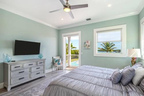 a bedroom with a large bed with a flat screen tv at Waterlane House -Pool & Boat Dock in Stock Island