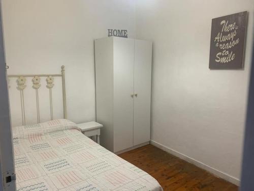 a white bedroom with a bed and a closet at Piso amplio en pleno centro in Santander