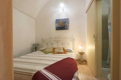 a bed with two pillows in a small bedroom at Corte Antica 2 in Presicce