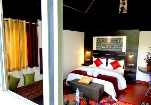 2 fotos de un dormitorio con cama y sofá en vattachalil villa, en Anachal