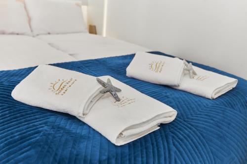 due asciugamani bianchi con una croce sopra un letto di Golden Hour Apartments- Plac Słowiański 43 a Świnoujście