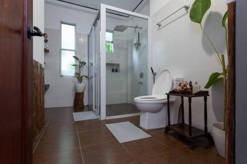 a bathroom with a toilet and a glass shower at Villa Raya w Outdoor Cinema, Bonfire, Treehouse & Parking in Vigan