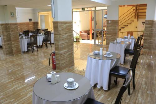 un restaurante con mesas y sillas blancas y una escalera en Hotel Garden Wilson, en Iquique