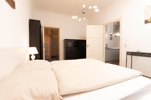 een witte slaapkamer met een groot wit bed. bij Altbau-Apartment im Westend I Küche I Hochparterre in Wiesbaden