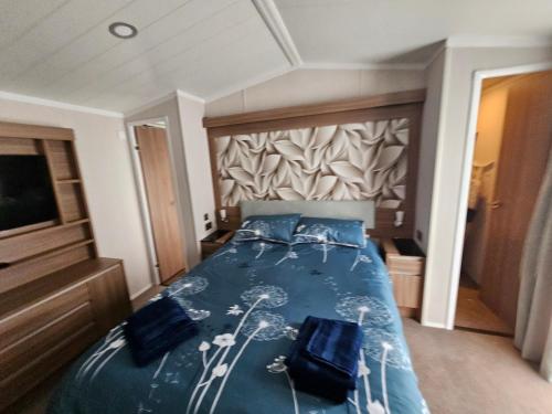 1 dormitorio con 1 cama con 2 almohadas azules en The MINI LODGE en Meliden