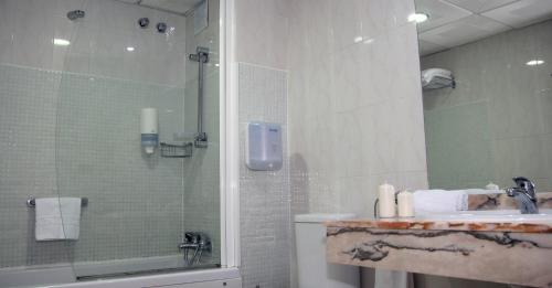 een badkamer met een douche en een wastafel bij Hospedium Hotel Blu Torre de Sevilla in Torre de la Reina