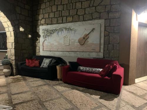 a living room with two couches and a guitar on the wall at Residenza Ca' degli Enzi in Verona