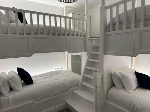 1 dormitorio con 2 literas y escalera en New Sandpiper Apartments, en Fleetwood