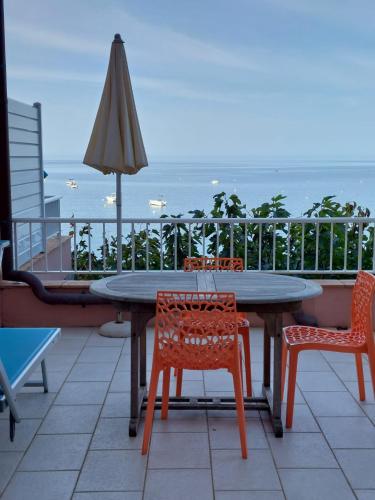a table and chairs and an umbrella on a balcony at Résidence Villa Nova in Tiuccia