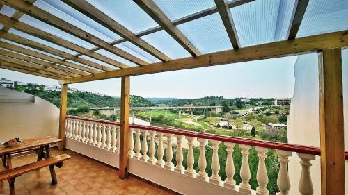 a balcony with a bench and a large window at Casa Família Cardoso in Tavira